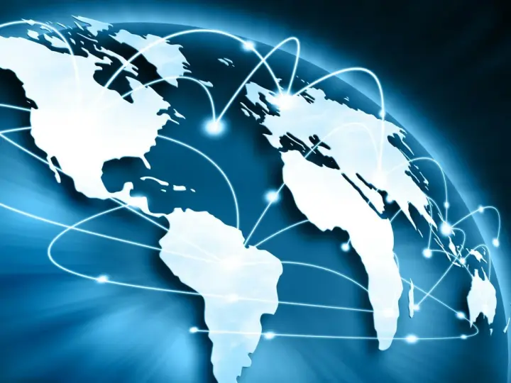 Carte du monde bleue avec des lignes lumineuses connectant les continents, symbolisant le commerce international et un futur doctorat.
