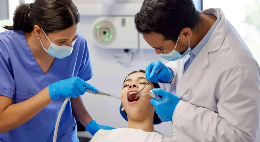 Dentiste et assistante examinant une patiente. Le coût d'une étude orthodontiste peut varier.