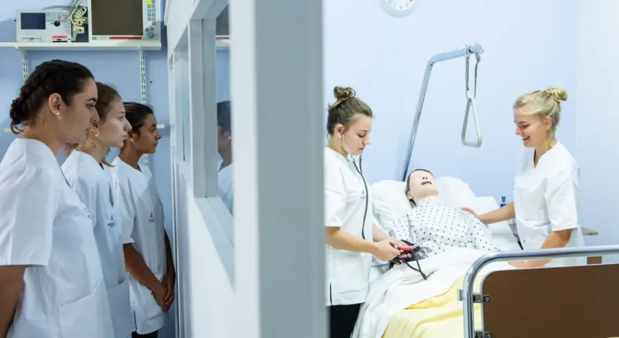 Étudiantes en formation à une école d'infirmière en Belgique. Elles apprennent les gestes de soins sur un mannequin.