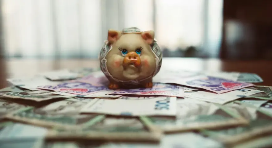 Un cochon tirelire sur des billets de banque, symbolisant le coût de la vie à Singapour pour un étudiant.