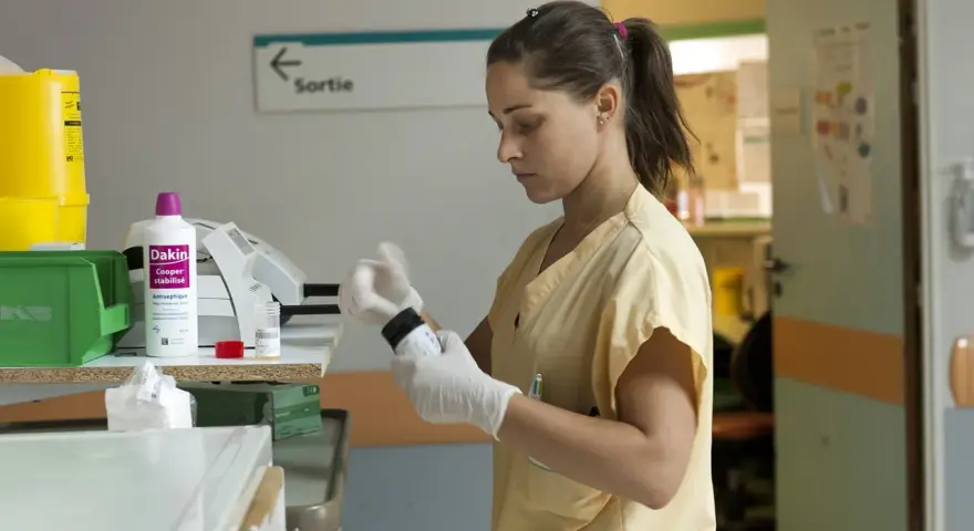 Une étudiante en soins infirmiers à l'école d'infirmière Bruxelles prépare un médicament.