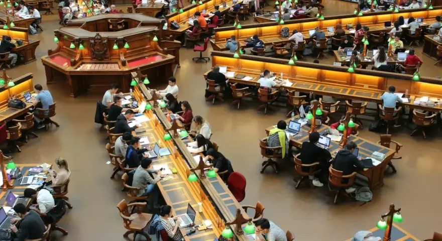 Vue d'ensemble d'une grande bibliothèque où des étudiants travaillent sur leurs ordinateurs portables. Le coût de la vie en Écosse, notamment pour les études, est un sujet de préoccupation.