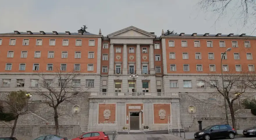 Bâtiment en brique avec des colonnes, des fenêtres et un toit mansardé. Le nom "CEU San Pablo" est visible sur la façade.