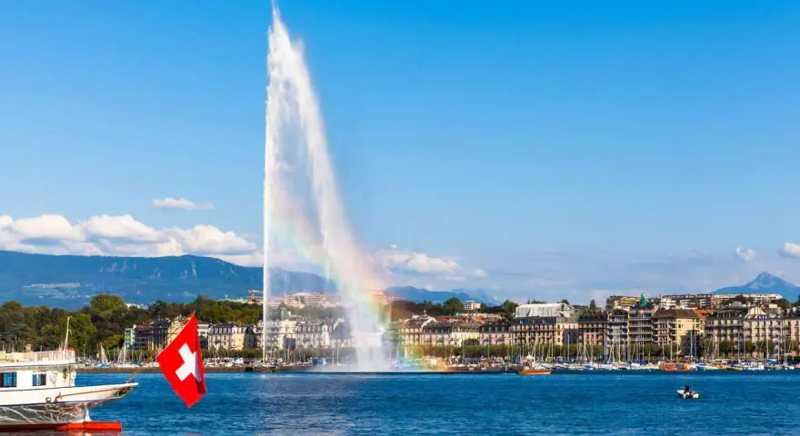 Le Jet d'Eau de Genève, un arc-en-ciel dans la brume, symbolise la beauté de comment vivre en Suisse.