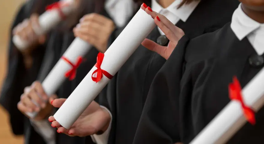 Diplômés en toges noires tenant des parchemins, un rêve pour ceux qui veulent faire ses études de kiné en Europe.