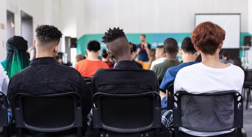 Des étudiants écoutent un conférencier, peut-être lors d'un événement sur le prix de l'université de New York.