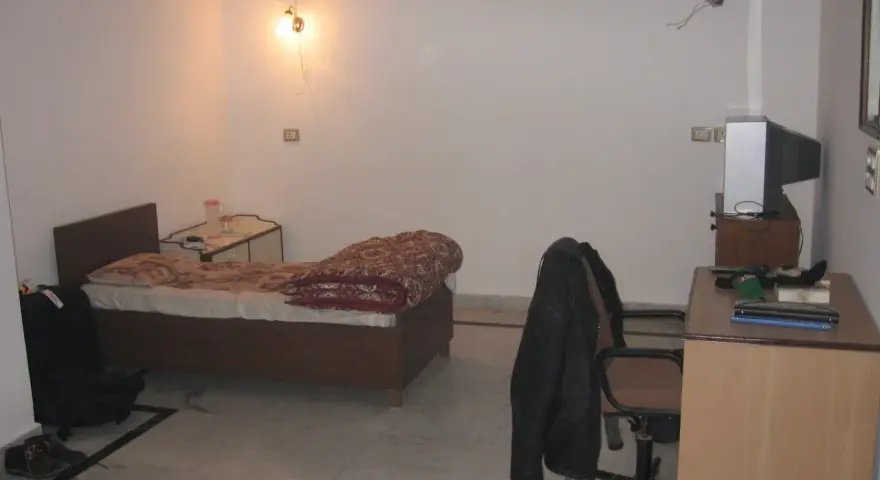 Chambre modeste en Inde, avec un lit, un bureau et une télévision. Un aperçu du cout de la vie en Inde.