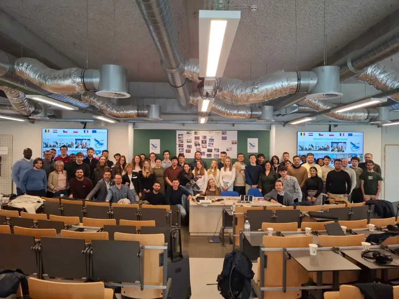 Groupe d'étudiants et d'enseignants devant un écran affichant