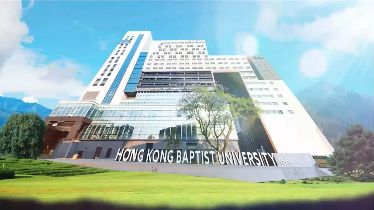 Le b&acirc;timent moderne de la Hong Kong Baptist University se dresse sous un ciel bleu, entour&eacute; de verdure et de montagnes.