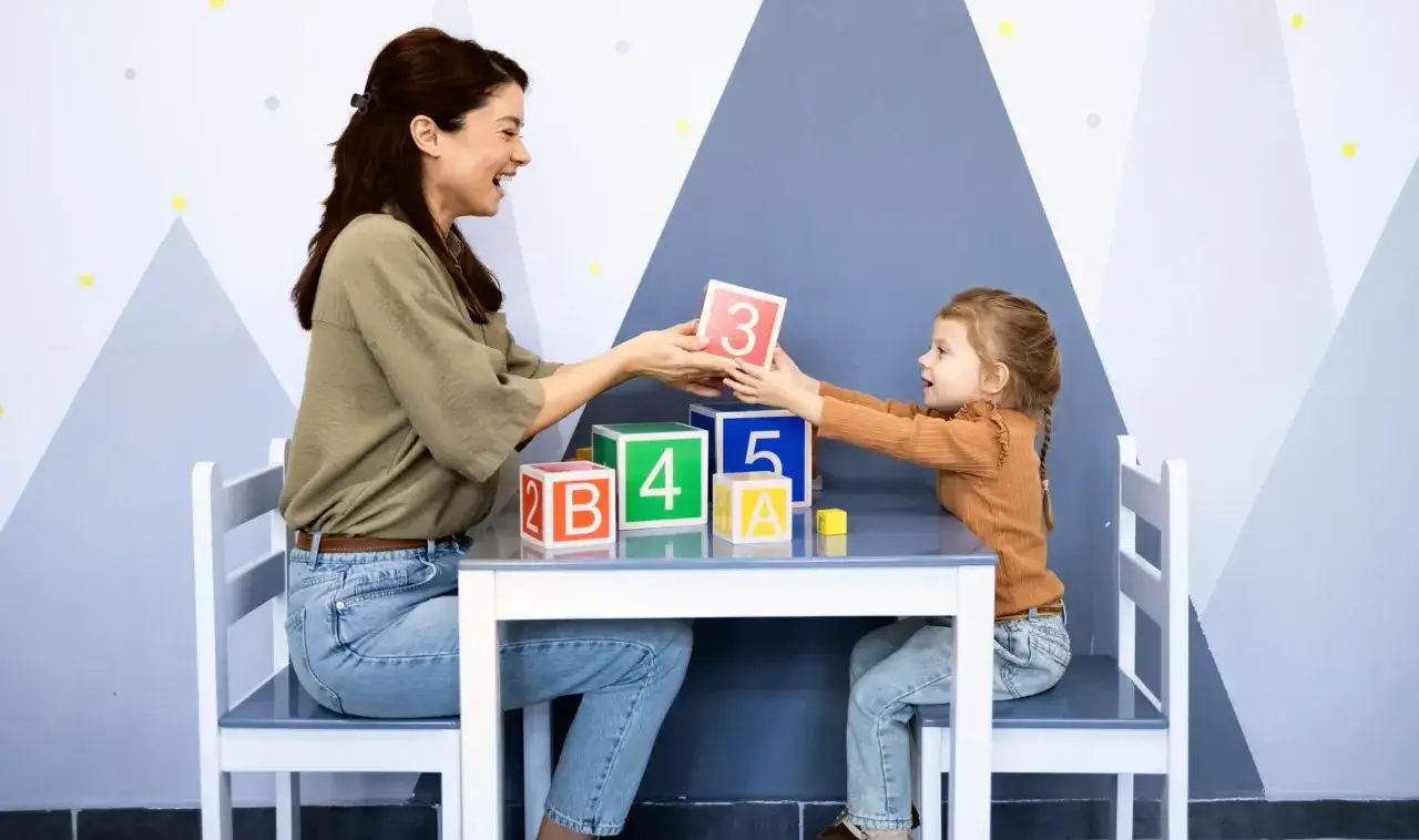 Une femme et une enfant jouent avec des cubes num&eacute;rot&eacute;s. Une sc&egrave;ne qui illustre parfaitement le master psychop&eacute;dagogie &agrave; distance.