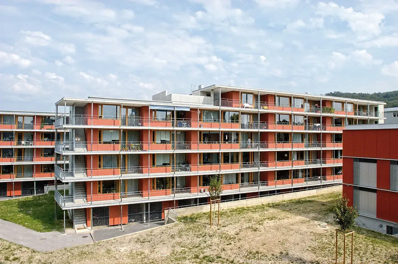 Immeuble moderne de logement &eacute;tudiant suisse aux fa&ccedil;ades orange vif, balcons et grandes fen&ecirc;tres.