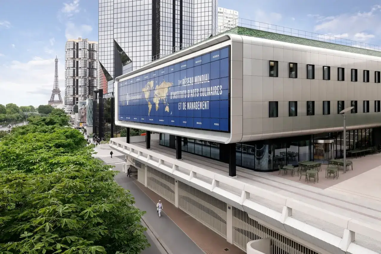 Le Cordon Bleu Paris, un r&eacute;seau mondial d'instituts culinaires, s'affiche fi&egrave;rement sur un b&acirc;timent moderne, avec la Tour Eiffel en arri&egrave;re-plan.