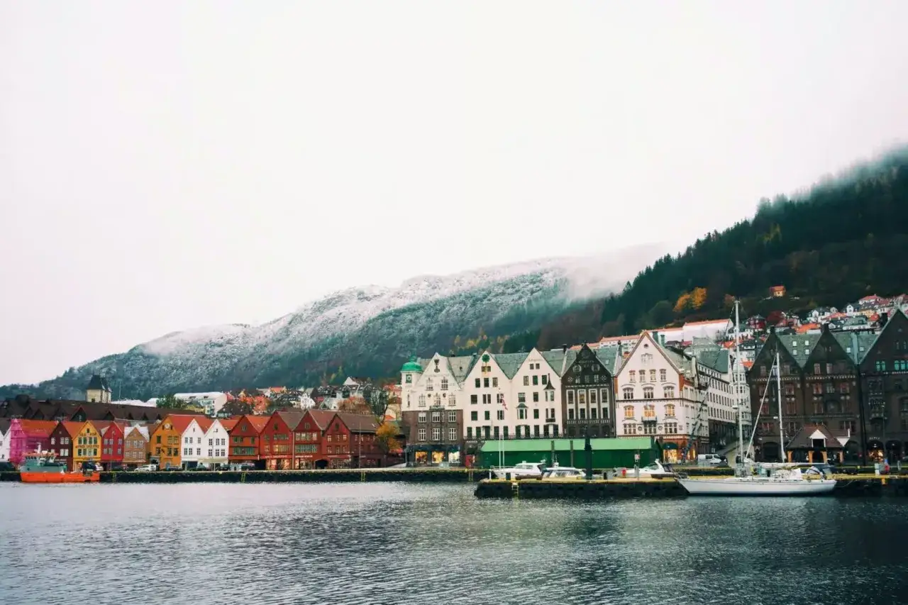 Vue du port de Bergen, Norvège, avec ses maisons colorées et ses montagnes enneigées. Un aperçu du coût de la vie en Norvège.