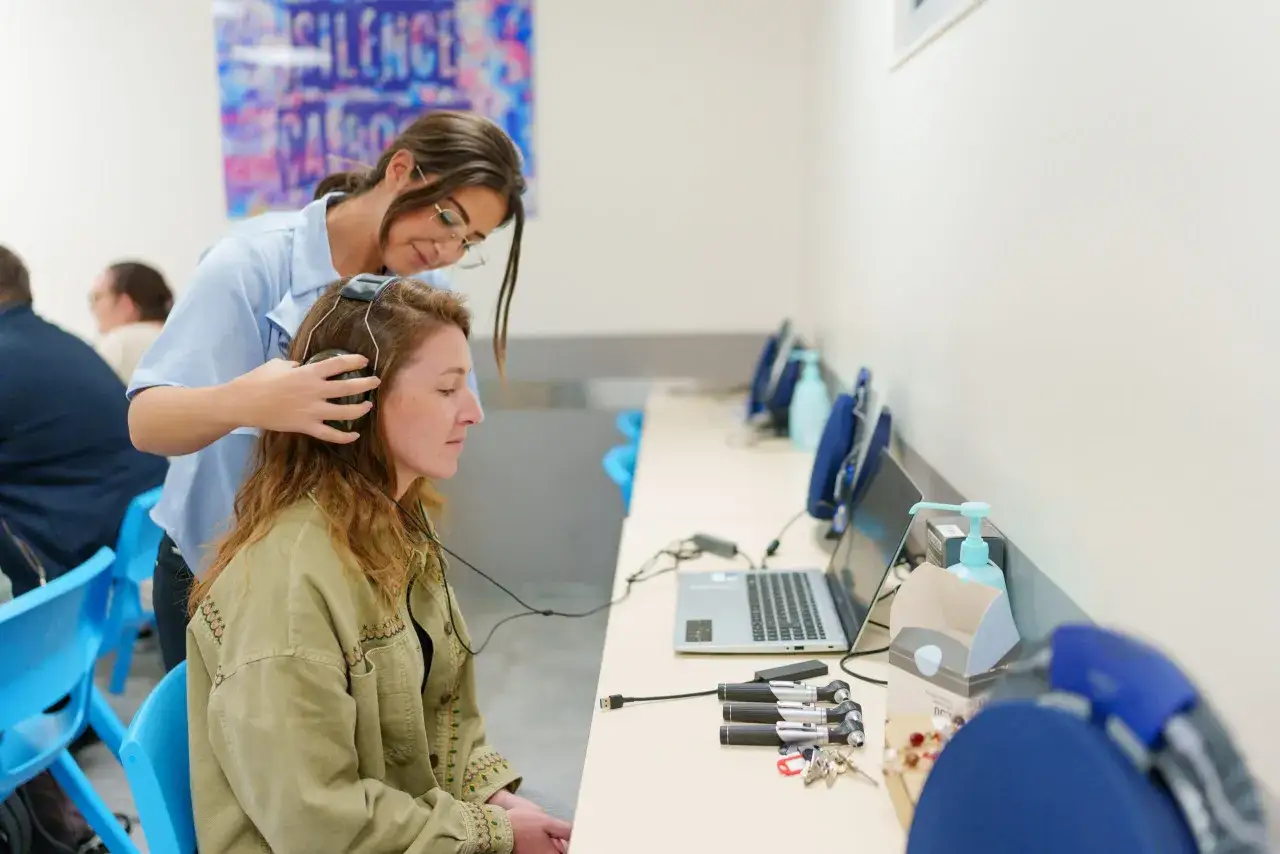 Une jeune femme passe un test auditif, peut-&ecirc;tre dans le cadre de sa formation pour obtenir son dipl&ocirc;me d'audioproth&eacute;siste en Espagne.