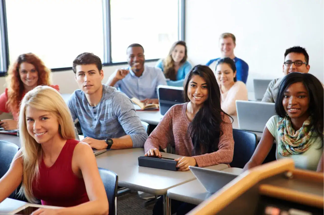 Des étudiants souriants en classe, un aperçu des universités en Angleterre qui acceptent les étrangers pour une éducation internationale.