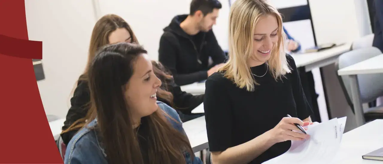 &Eacute;tudiantes souriantes en classe, pr&eacute;parant leur master marketing &agrave; distance.