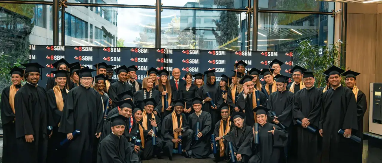 Groupe d'&eacute;tudiants dipl&ocirc;m&eacute;s en toges noires et chapeaux, c&eacute;l&eacute;brant la fin de leurs cours en Suisse.