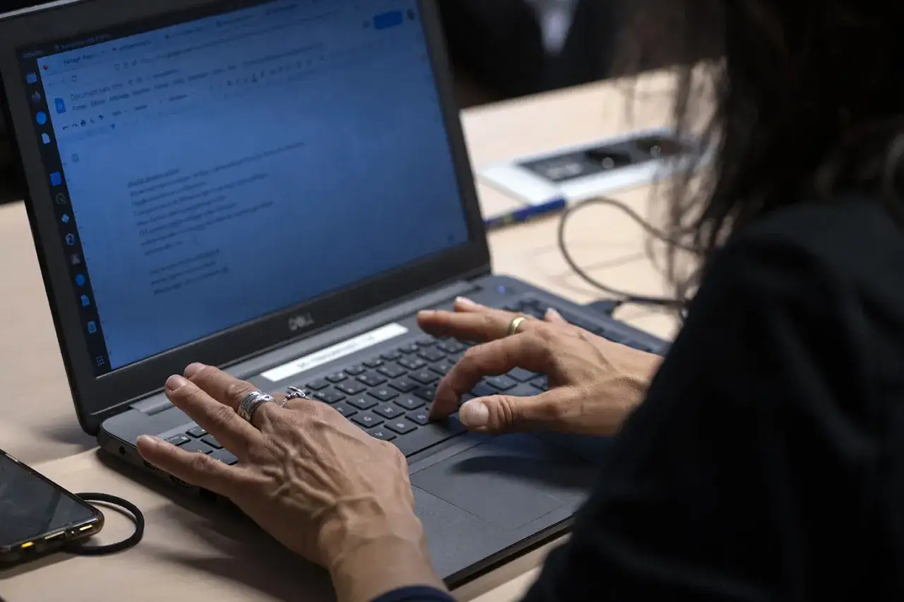 Une personne travaille sur son ordinateur portable, effectuant une master édition à distance.