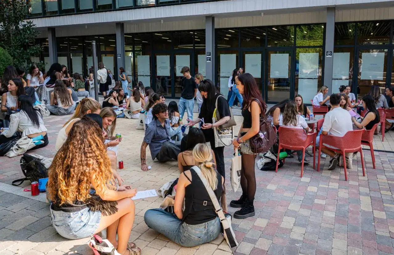Des &eacute;tudiants discutent et &eacute;tudient en groupe sur la place ceu san pablo, profitant du soleil.