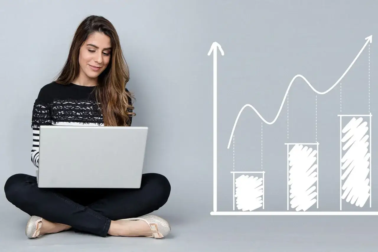 Jeune femme travaillant sur son ordinateur portable, symbolisant son master économie à distance et sa progression vers le succès.