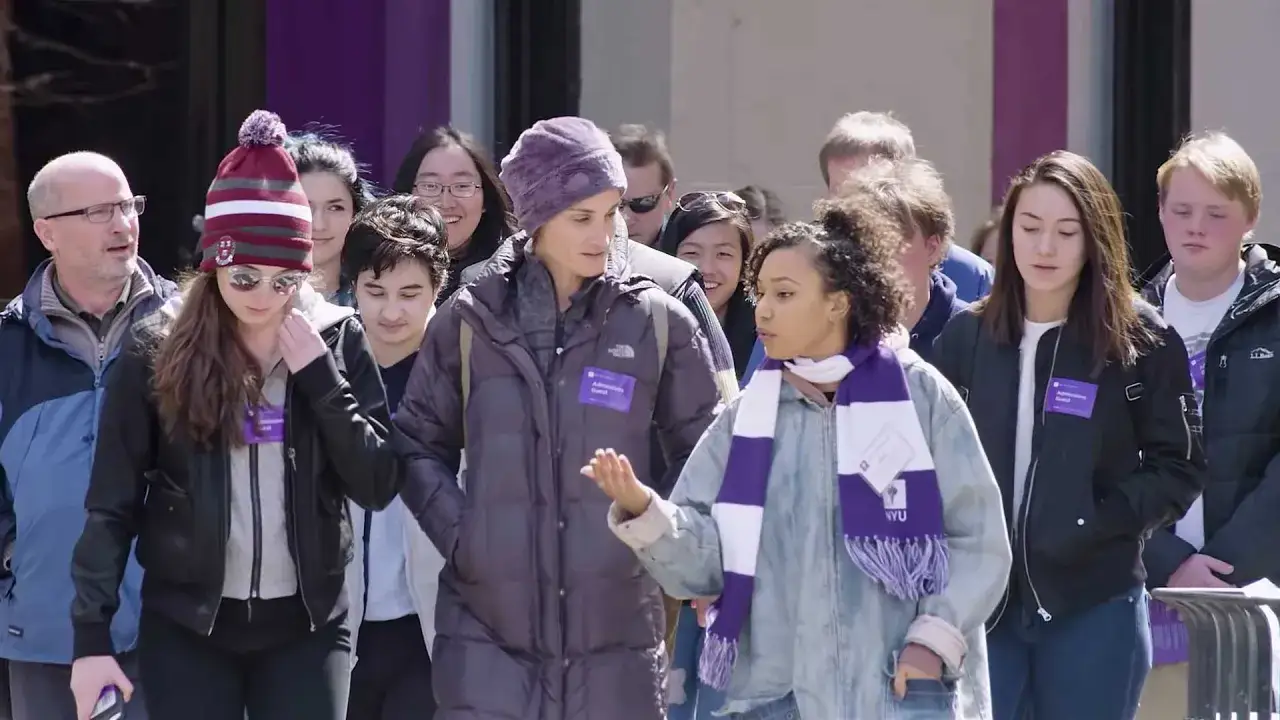 Visite guidée à l'université de New York. Des étudiants et un adulte portent des badges