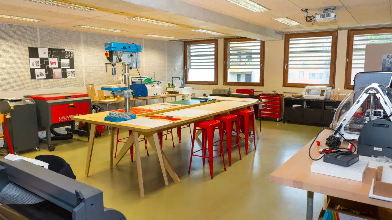 Atelier de BTS Design d'Espace à Paris : perceuse, imprimante 3D, machine laser, et tables de travail pour créer.