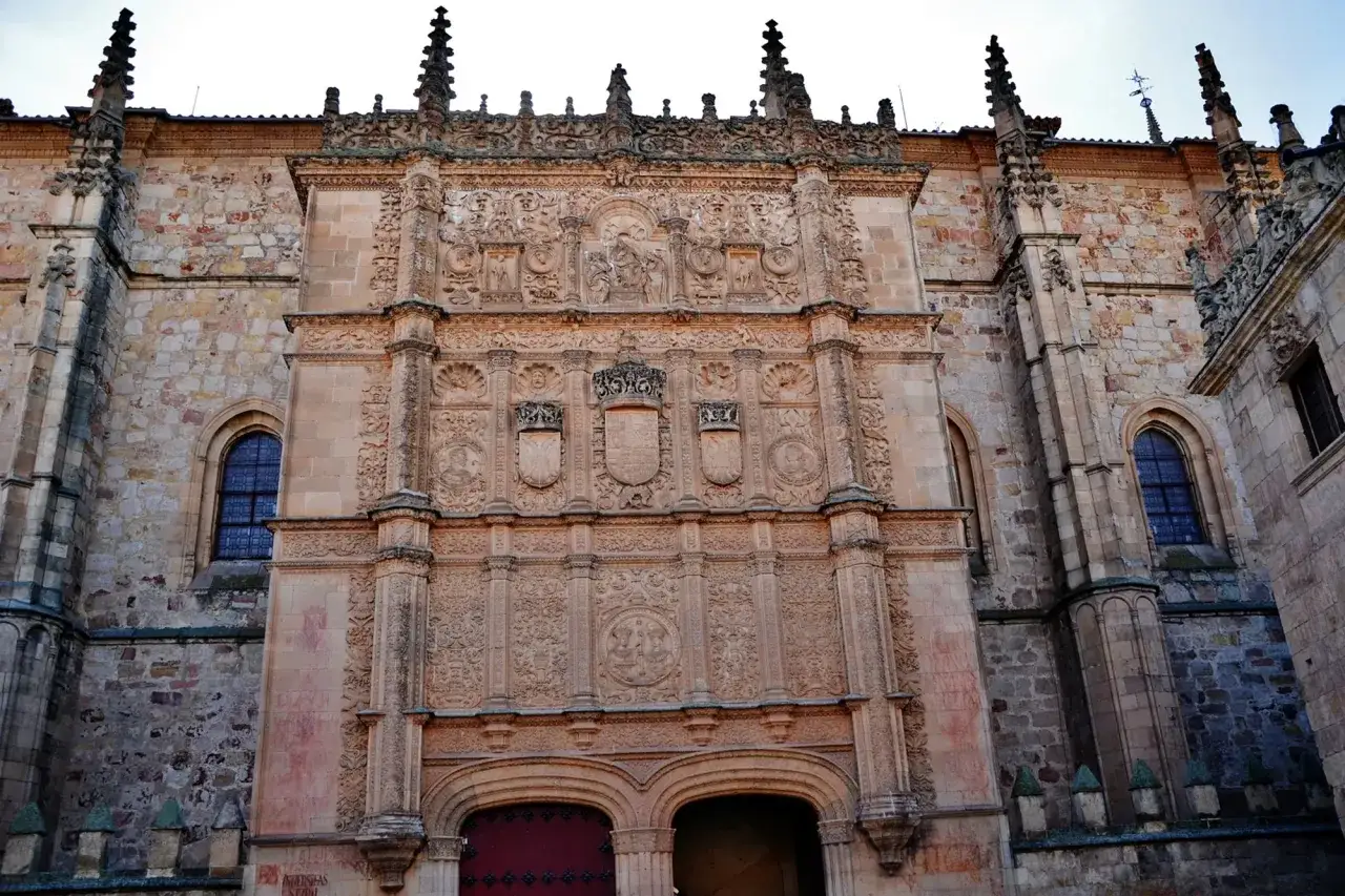 Fa&ccedil;ade orn&eacute;e de l'universit&eacute; pontificale de Salamanque, avec ses blasons et sculptures complexes.