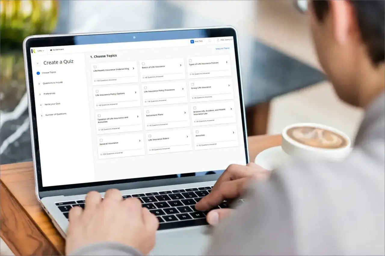 Un &eacute;tudiant pr&eacute;pare son bts assurance &agrave; distance en choisissant des sujets sur son ordinateur portable, une tasse de caf&eacute; &agrave; proximit&eacute;.