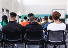 Des étudiants écoutent un conférencier, peut-être lors d'un événement sur le prix de l'université de New York.