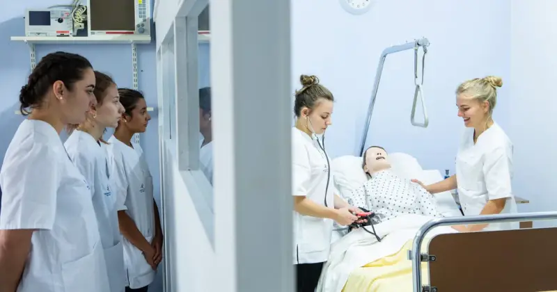 Étudiantes en formation à une école d'infirmière en Belgique. Elles apprennent les gestes de soins sur un mannequin.