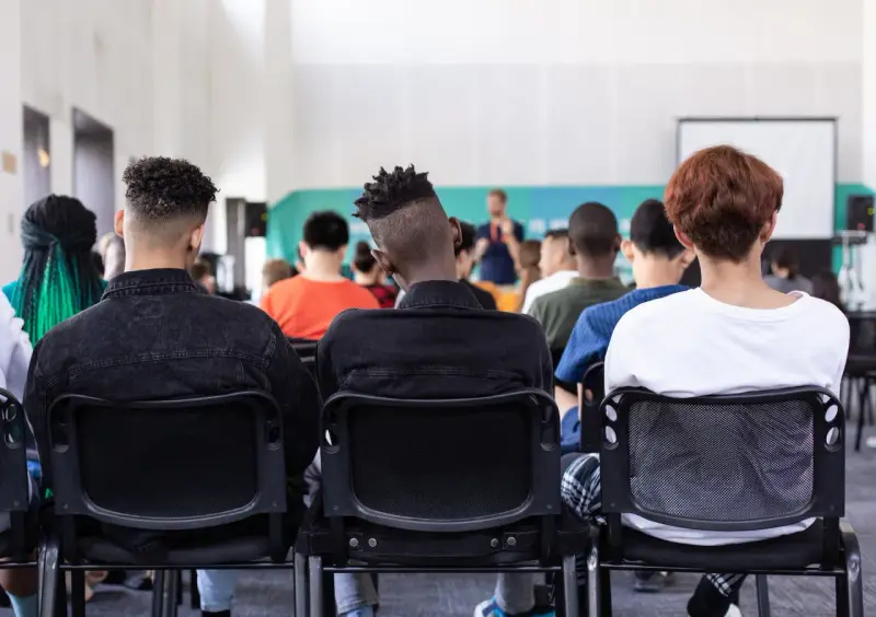 Des étudiants écoutent un conférencier, peut-être lors d'un événement sur le prix de l'université de New York.